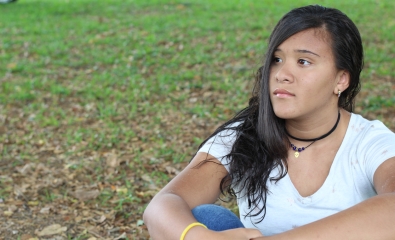 Teenage girl alone outside in park