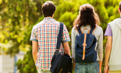 Teenage kids walking outside on sunny day with backpacks