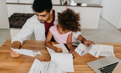 Dad struggling with debt, sitting with young daughter