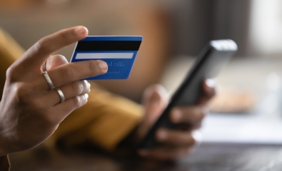 Young person, close up of hands holding credit card and phone