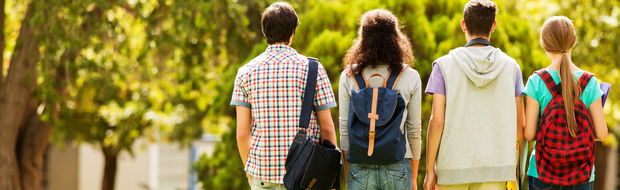 Teenage kids walking outside on sunny day with backpacks