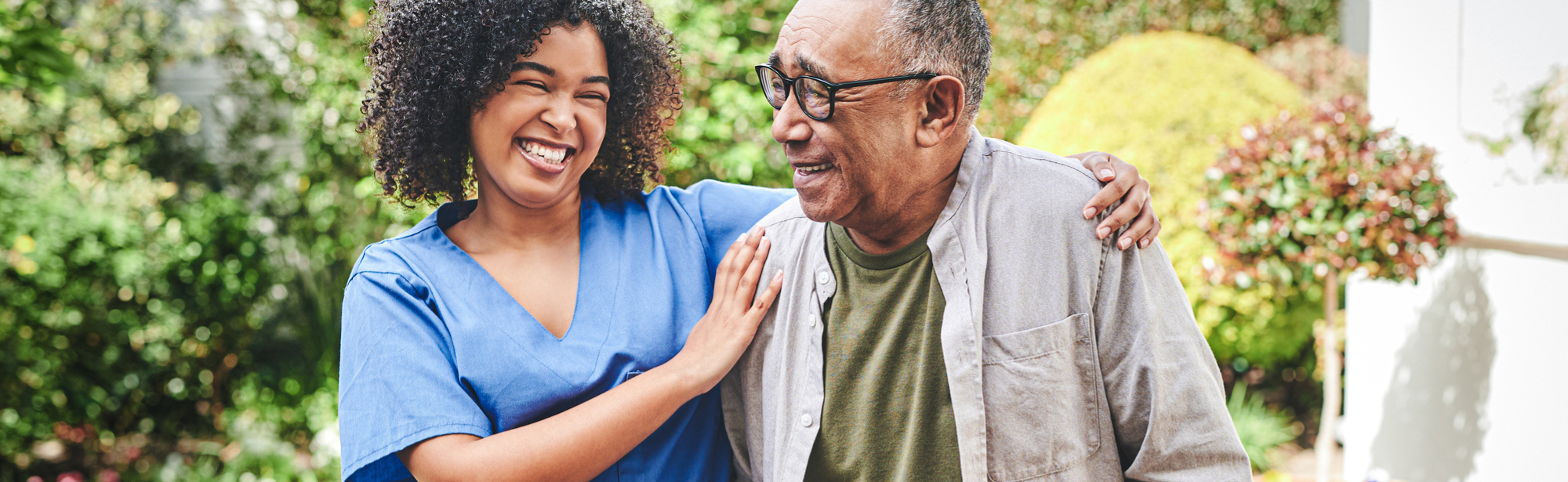 Smiling nurse assist elderly man walking