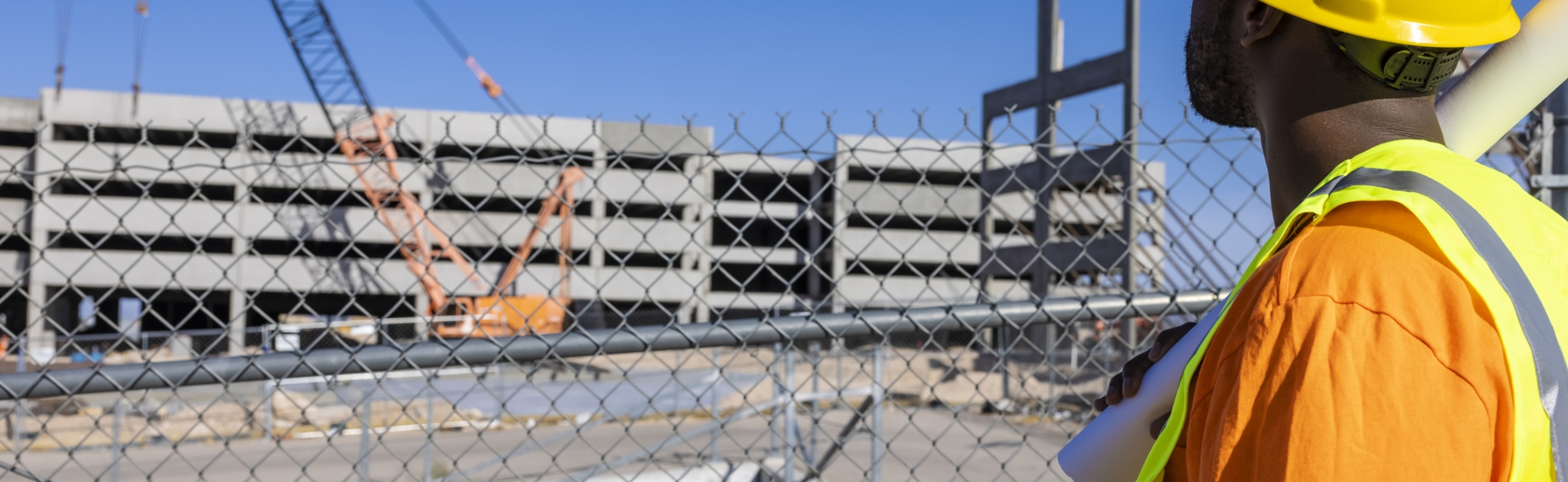 Construction worker in hardhat looks at construction site